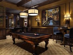 a pool table and chairs in a room with paintings on the wall, chandeliers hanging from the ceiling