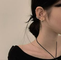 a woman with ear piercings wearing a black shirt