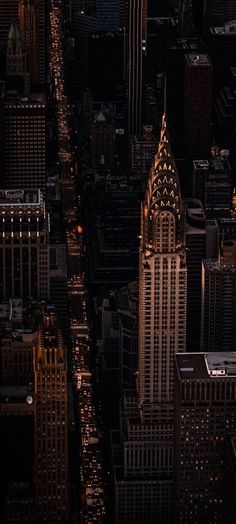 an aerial view of skyscrapers at night in new york city, with the lights on