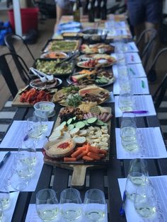 a long table filled with lots of food on top of plates and glasses next to each other