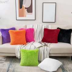 a living room filled with lots of pillows on top of a white couch next to a rug