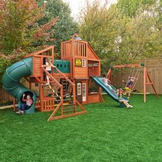 two children playing on a wooden playset in the backyard with green grass and trees