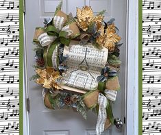 a wreath made out of sheet music is hanging on the front door