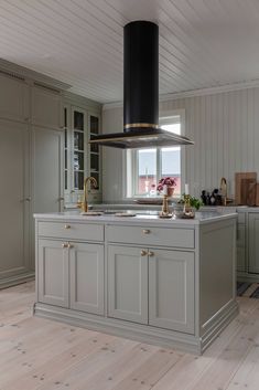 a large kitchen with an island in the middle and lots of cupboards on both sides