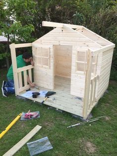 a man working on a small wooden shed