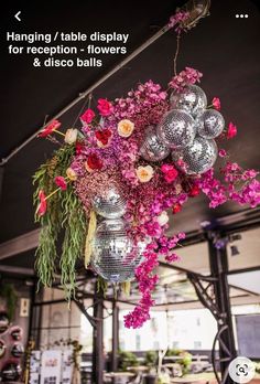 an arrangement of flowers and disco balls hanging from the ceiling