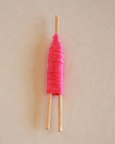 two wooden sticks with pink yarn on them