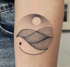 a black and white photo of a wave tattoo on the left arm with an eclipse in the background