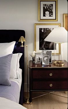 a bedroom with a bed, nightstand and pictures on the wall