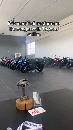 a room filled with lots of motorcycles parked in front of each other on the floor