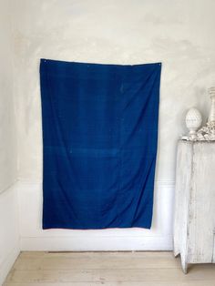 a blue blanket hanging on the wall next to a dresser