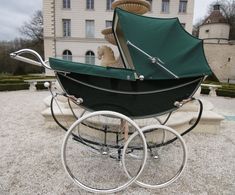 an old fashioned baby carriage in front of a large building