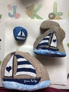 two painted rocks with sailboats on them