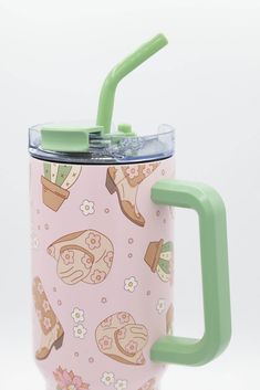 a pink and green coffee cup with a handle on it's side is shown