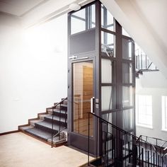 an open staircase leading up to the second floor in a home with glass walls and steel handrails