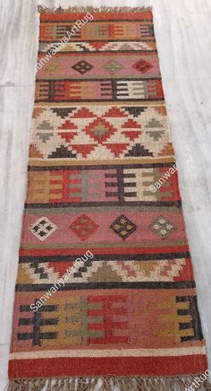 a multi colored rug with fringes on the floor