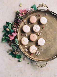 a metal tray filled with different types of pastries on top of a marble table