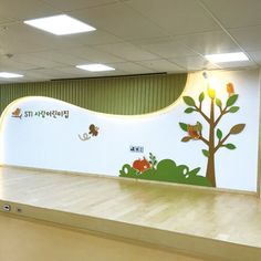 an empty room with painted trees and animals on the wall