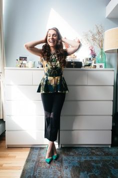 a woman standing in front of a dresser