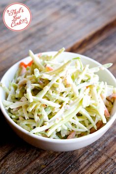 a white bowl filled with coleslaw on top of a wooden table