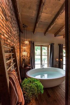 a bathtub in the middle of a room with wooden floors and exposed beams on the ceiling