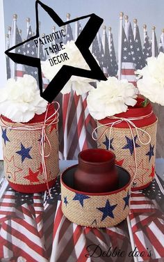 two patriotic vases with flowers in them on top of an american flag table cloth