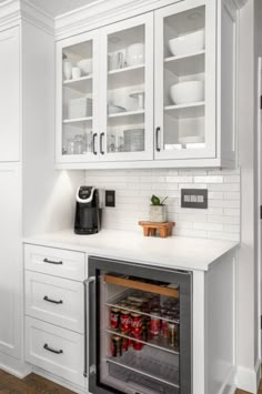 a kitchen with white cabinets and an open refrigerator