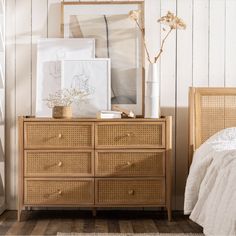 a bedroom with wicker furniture and pictures on the wall, including a wooden dresser