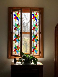 a potted plant sitting on top of a table next to a stained glass window