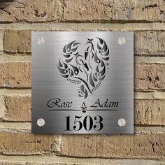 a metal sign on the side of a brick wall that says rose and adam 130