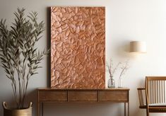 a painting on the wall next to a table with two chairs and a potted plant