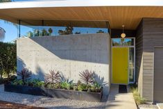 a house with a yellow door and some plants