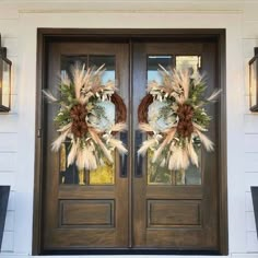 two wreaths on the front door of a house