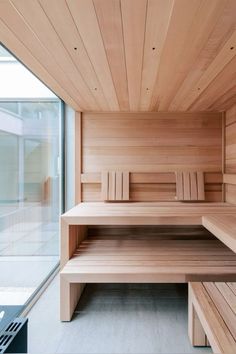 a wooden sauna with benches in front of a glass wall and sliding doors to the outside