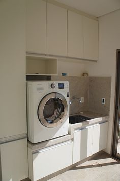 a washer and dryer sitting in a kitchen next to each other on top of cabinets