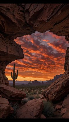 the sun is setting in the desert with rocks and cacti on it's sides