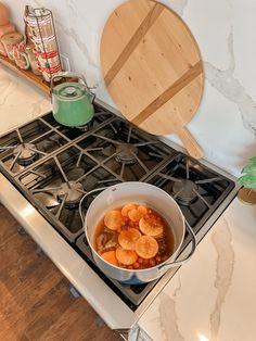 a pot filled with food sitting on top of a stove next to a wooden spatula