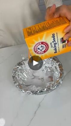 someone is pouring orange juice into a glass bowl on a marble counter top with a measuring tape