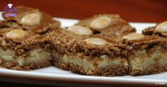 two pieces of dessert sitting on top of a white plate with peanut butter toppings