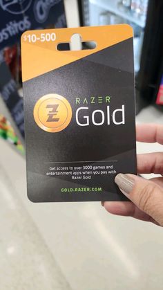 a person holding up a card that says razer gold