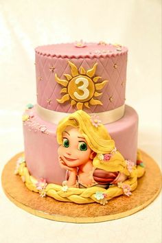 a pink and gold birthday cake with a princess figure on it's tiers