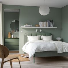 a bedroom with green walls and white bedding