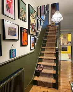 there is a staircase with pictures on the wall and carpeted steps to the second floor