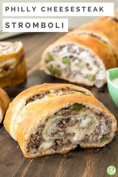 some food is laying out on a wooden table with the words philly cheesesteak stromboli