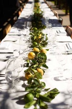 the long table is set with lemons and greenery