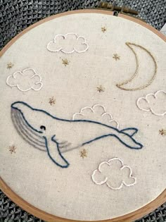 a close up of a embroidery on a piece of cloth with a whale in the sky