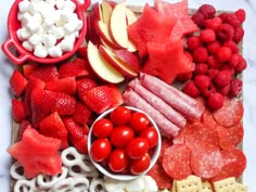 an assortment of fruits, vegetables and meats on a cutting board for a snack