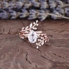 a close up of a ring on top of a piece of wood with lavender flowers in the background