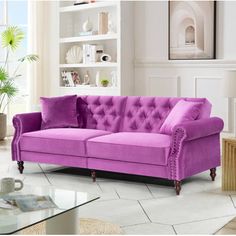 a living room with a purple couch and coffee table