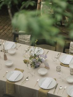 the table is set with plates, silverware and napkins for an elegant dinner